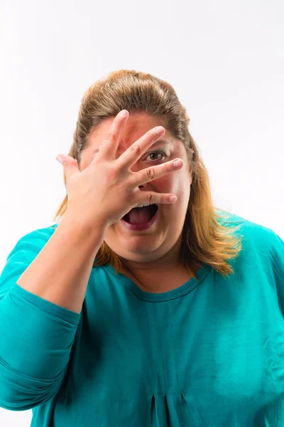 Mulher assustada espreitando dos dedos sobre o rosto — Fotografia de Stock