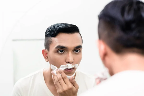 Uomo che applica schiuma da barba — Foto Stock