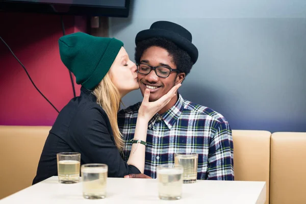 Girlfriend kissing her boyfriend at the restaurant — Stock Photo, Image