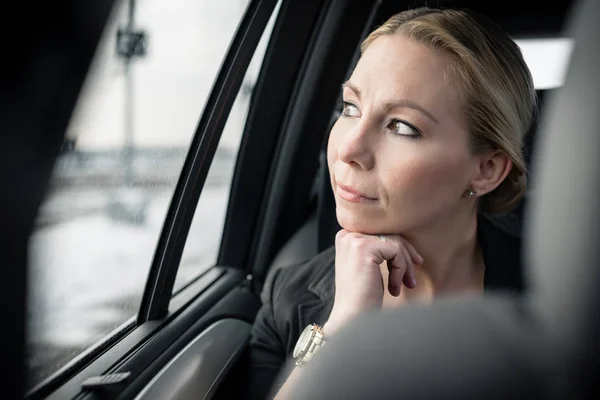 Nachdenkliche Geschäftsfrau im Auto unterwegs — Stockfoto