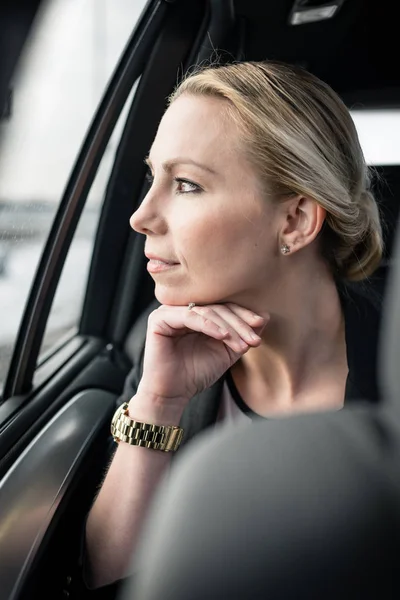 Geschäftsfrau blickt durch Autofenster — Stockfoto