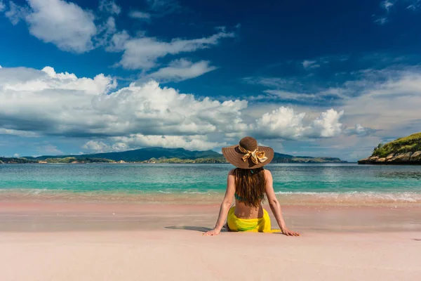 Ung kvinna sitter i sanden på rosa Beach i Komodo Island — Stockfoto