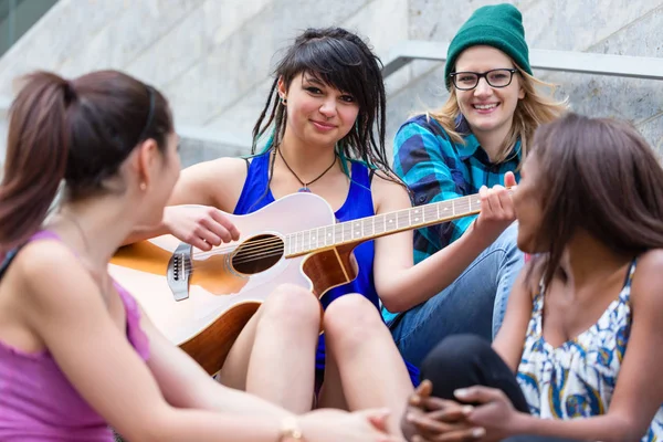 Mulher dobrando guitarra com seus amigos — Fotografia de Stock