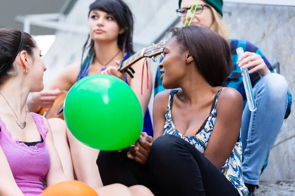 Amigos sentados en la escalera celebrando — Foto de Stock