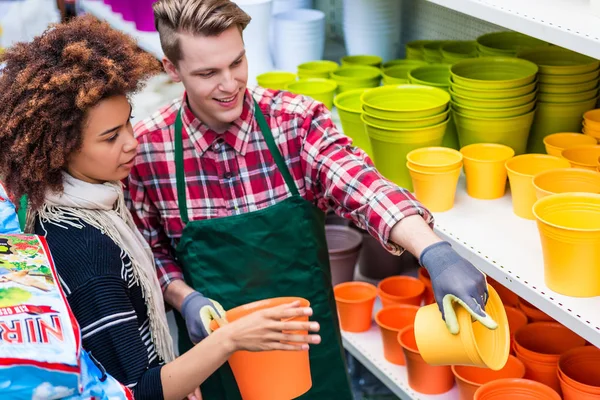 Klant kopen van plastic potten op het advies van een nuttig werknemer — Stockfoto