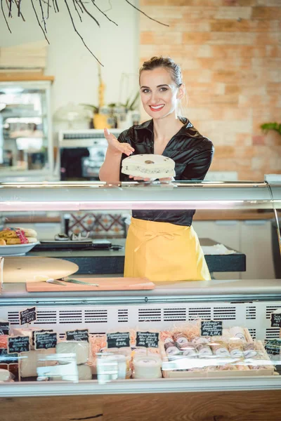 Salesgirl vendendo queijo em deli ou supermercado — Fotografia de Stock