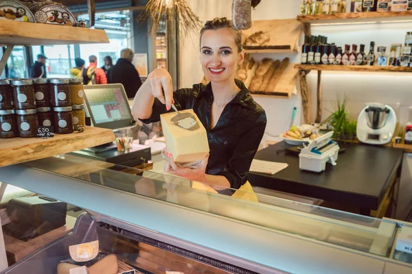 Customer trying bit of cheese at the deli counter — Stock Photo, Image