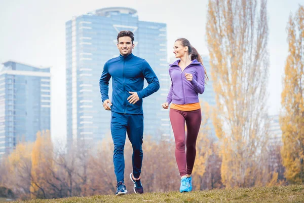 Urban jogging - couple running in autumn city