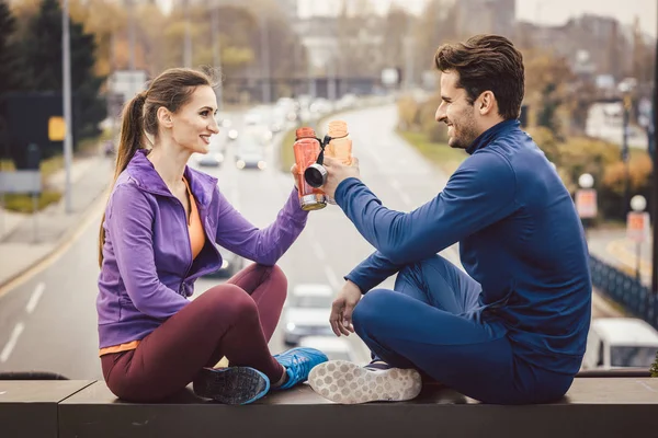 Mujer y hombre bebiendo agua en el descanso del entrenamiento de fitness — Foto de Stock