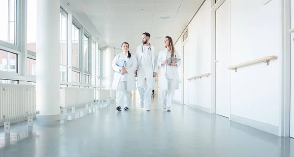 Doctors, two women and a man, in hospital — Stock Photo, Image