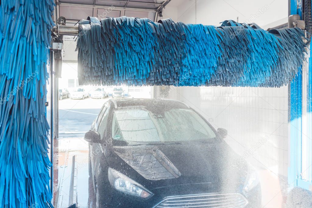 Brush turning in car wash with vehicle in it