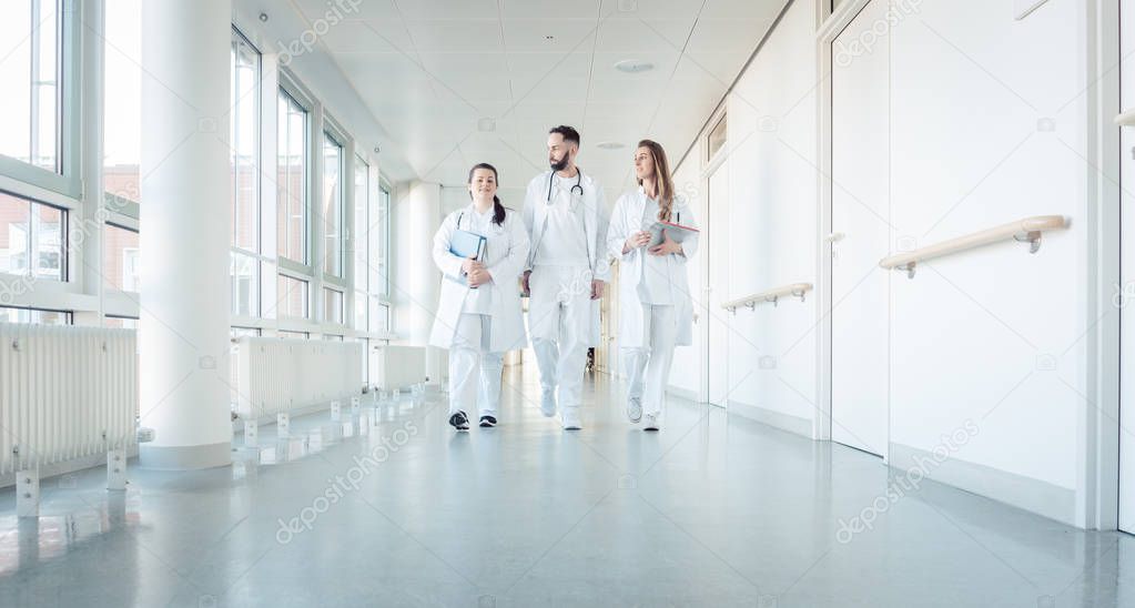 Doctors, two women and a man, in hospital