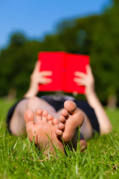 Woman feet while reading a book — Stock Photo, Image