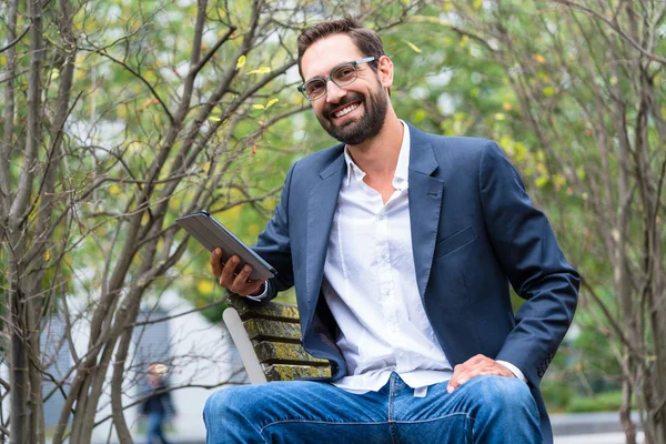 Zakenman zittend op de bank holding digitale tablet — Stockfoto