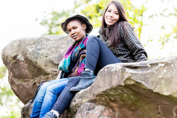 Dua wanita muda duduk di atas batu — Stok Foto