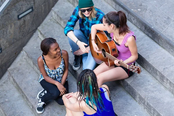 Женщина играет на гитаре со своими друзьями — стоковое фото