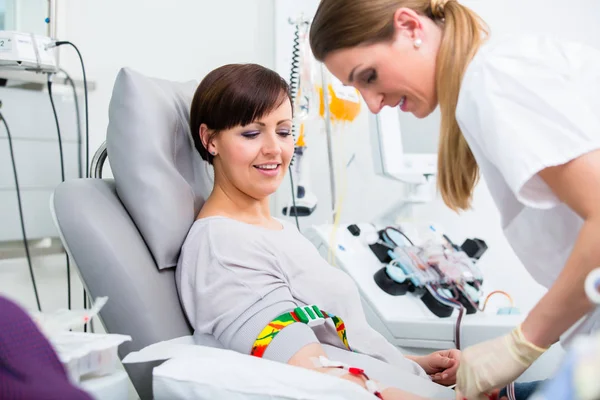 Assistente medico che controlla l'accesso al donatore di sangue femminile — Foto Stock