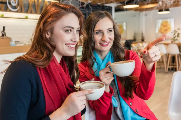 Dos mujeres jóvenes y hermosas bebiendo juntos chocolate caliente —  Fotos de Stock