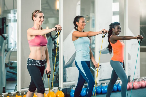 Полная длина трех подходящих женщин, тренирующихся с полосами сопротивления — стоковое фото