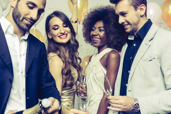 Man, on new year or birthday party opening bottle of champagne — Stock Photo, Image