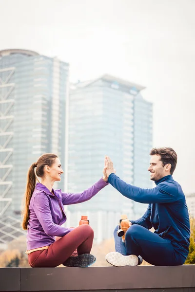 Mulher e homem dando oi-cinco após o esporte de fitness em uma cidade — Fotografia de Stock