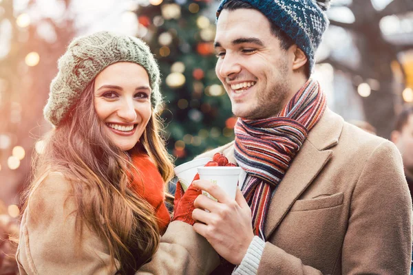 Mujer y hombre bebiendo vino caliente en el mercado de Navidad — Foto de Stock