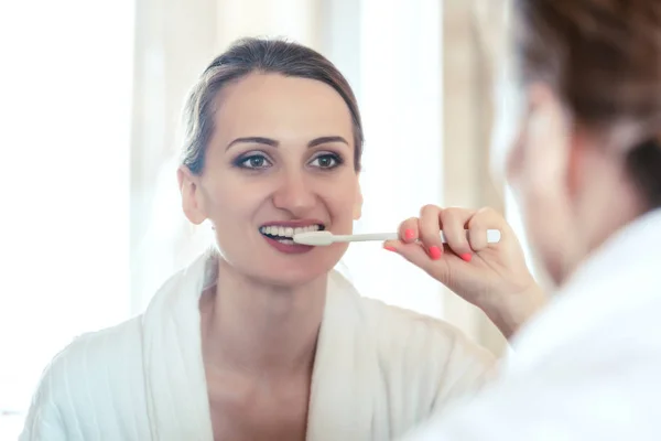 Kvinna borsta hennes tänder i hotellet med hand borste — Stockfoto