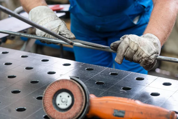 Worker in factory deburring workpieces of metal, close-up — Stock Photo, Image