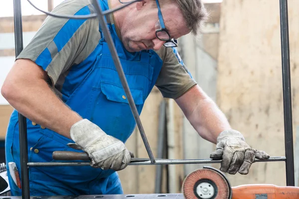 Werknemer in fabriek slijpen werkstukken van metaal — Stockfoto