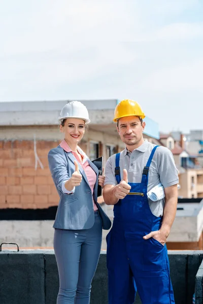 Arquitecto y trabajador de la construcción en el sitio dando pulgares hacia arriba — Foto de Stock