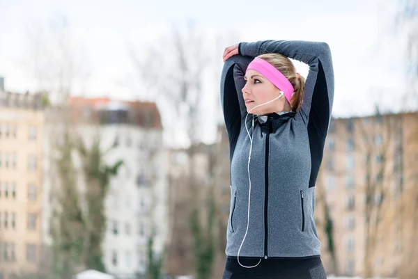 Mujer joven estirándose durante el entrenamiento deportivo al aire libre —  Fotos de Stock