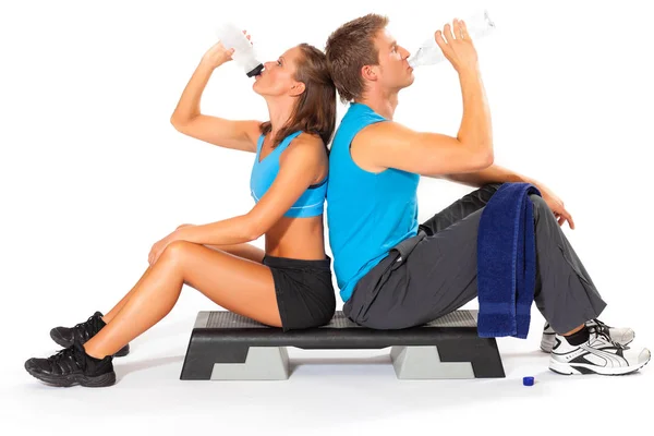 Hombre y mujer bebiendo agua después de hacer ejercicio —  Fotos de Stock