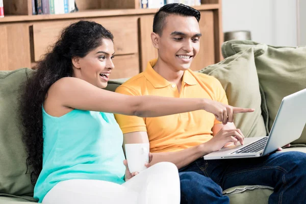 Χαμογελώντας νεαρό ζευγάρι ψάχνει στο φορητό υπολογιστή — Φωτογραφία Αρχείου
