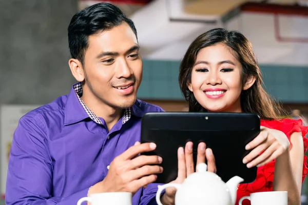 Happy couple watching together an online funny video on a tablet — Stock Photo, Image