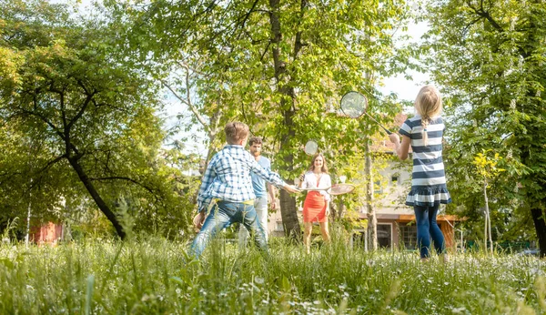 Familia jugando bádminton en un prado en verano — Foto de Stock