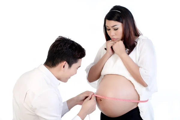 Manžel měření břicho těhotné manželky s páskou — Stock fotografie