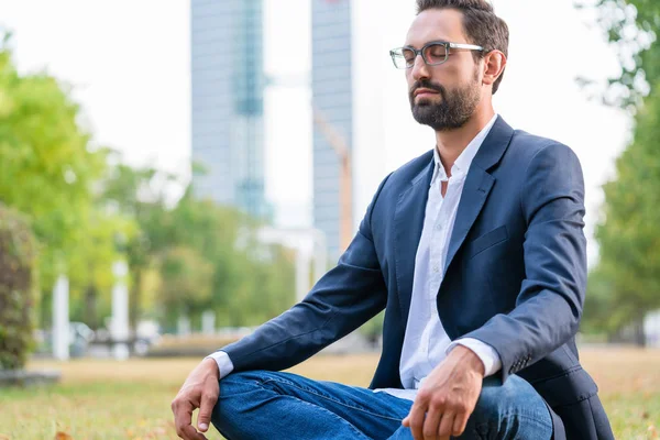 Businessman meditating in the park — Stock Photo, Image