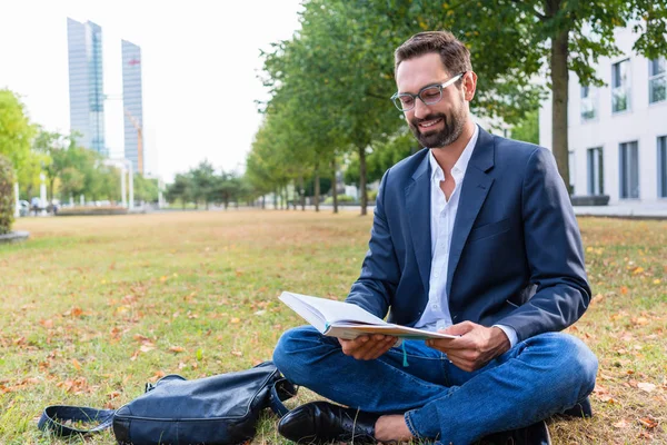Empresario leyendo libro en el parque —  Fotos de Stock