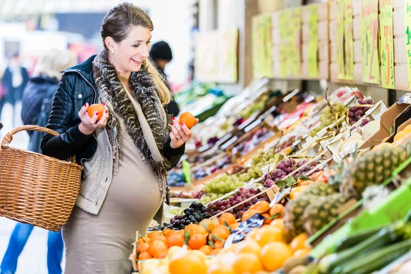 Mulher grávida comprando mantimentos no mercado de agricultores — Fotografia de Stock
