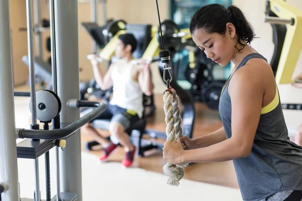 Déterminé jeune femme exerçant câble câble triceps extension — Photo