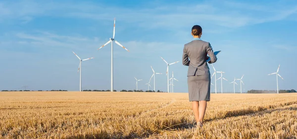 Investor in green energy looking at her wind turbines — Stock Photo, Image