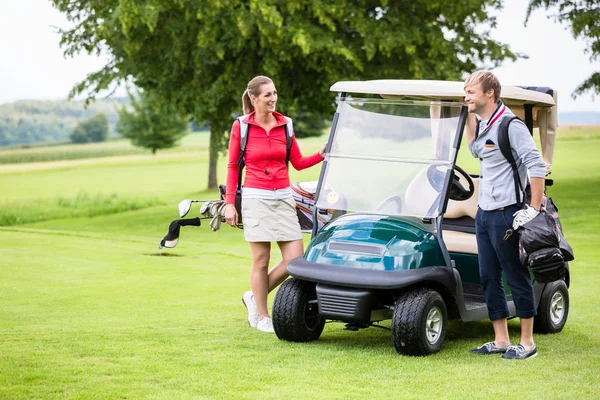 Sportovní pár stojící poblíž golfový vozík — Stock fotografie