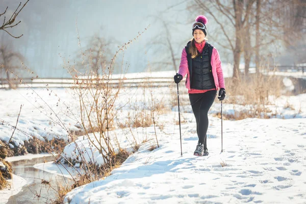 Fit woman Nordic walking in winter landscape — Stock Photo, Image