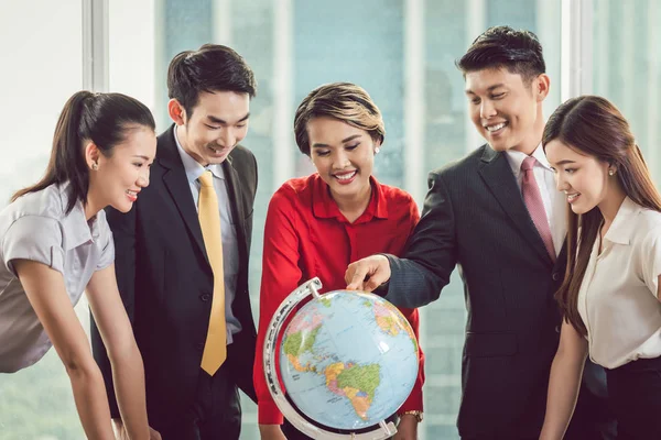 Groep ondernemers kijken naar globe — Stockfoto