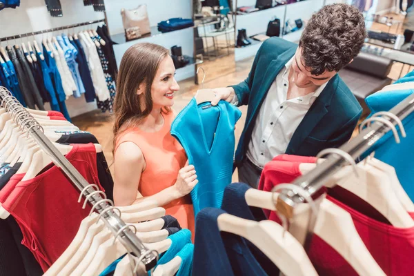 Mujer convenciendo a su pareja de comprar un nuevo vestido en la moda st —  Fotos de Stock