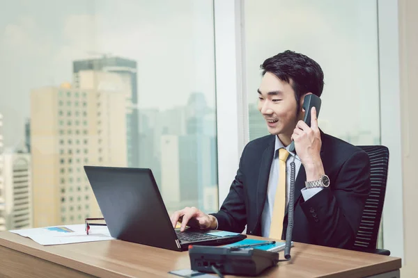 Sorrindo jovem empresário trabalhando no laptop — Fotografia de Stock