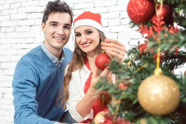 Para w domu dekorowanie drzewo na Boże Narodzenie — Zdjęcie stockowe