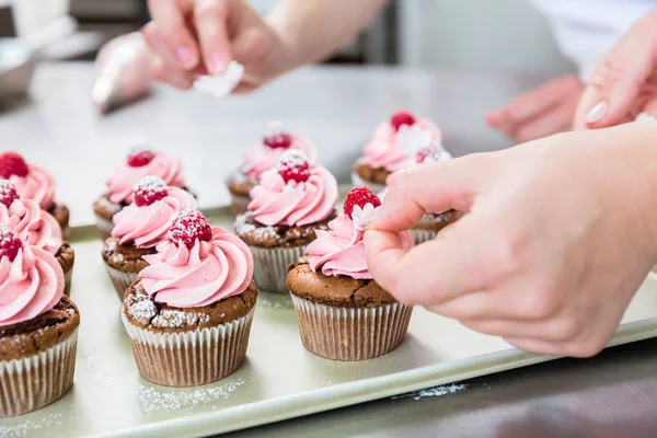 Mulheres em pastelaria trabalhando em muffins — Fotografia de Stock