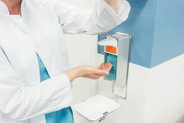 Доктор чистит и дезинфицирует руки в больнице — стоковое фото