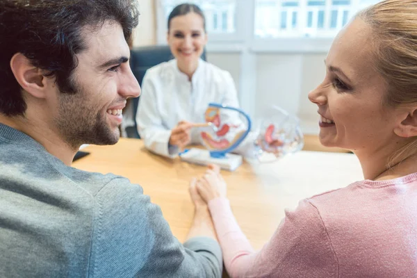 Couple wishing to have children in fertility clinic with doctor — Stock Photo, Image